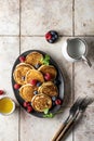 Pancakes in ceramic plate with berries, mint leaves and forks, top view Royalty Free Stock Photo