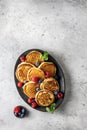 Pancakes in ceramic plate with berries, mint leaves and gravy boat, top view Royalty Free Stock Photo