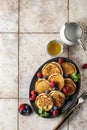 Pancakes in ceramic plate with berries, mint leaves, honey and forks, top view Royalty Free Stock Photo