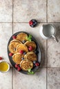 Pancakes in ceramic plate with berries, mint leaves and honey, top view Royalty Free Stock Photo