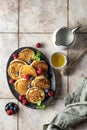 Pancakes in ceramic plate with berries, mint leaves and napkin, top view Royalty Free Stock Photo