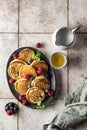 Pancakes in ceramic plate with berries, mint leaves and napkin, top view Royalty Free Stock Photo