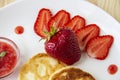 Pancakes with cheese and strawberries and sauce on a white dish against wood background. Delicious cheese pancake and strawberries Royalty Free Stock Photo