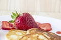 Pancakes with cheese and strawberries and sauce on a white dish against wood background. Delicious cheese pancake and strawberries Royalty Free Stock Photo