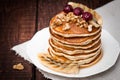 Pancakes with cherries, grilled banana and nuts on a dark background