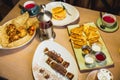 Pancakes with chocolate, salmon fish and tea kettle on table in cafe. Table with tasty food. Royalty Free Stock Photo