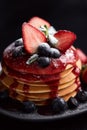 Pancakes close up, with fresh strawberry, blueberries, mint and jam