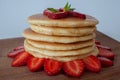 Pancakes with close up view, fresh strawberries and maple syrup on. Selective focus and isolated on white background. Royalty Free Stock Photo