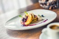 Pancakes and coffee. Pancakes with a cup of coffee and fresh fruits blueberries and herb decoration.