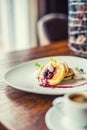 Pancakes and coffee. Pancakes with a cup of coffee and fresh fruits blueberries and herb decoration.