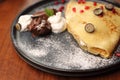 Pancakes with cottage cheese served with fresh fruit, whipped cream and chocolate, top view, close-up, selective focus. Royalty Free Stock Photo