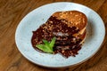 Pancakes covered with chocolate on a blue plate with a mint leaf Royalty Free Stock Photo