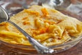 Pancakes with Crepe Suzette, in transparent plate with glass of liqueur. French cuisine, step by step recipe Royalty Free Stock Photo