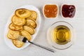 Pancakes in dish, fork, strawberry jam, peach jam, tea Royalty Free Stock Photo