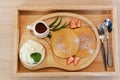 Pancakes with Egg Ingredients In a wooden plate decorated with stories and green leaves With cream and flour