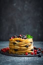 Pancakes with fresh berries and maple syrup on dark background Royalty Free Stock Photo