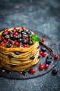 Pancakes with fresh berries and maple syrup on dark background Royalty Free Stock Photo