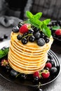 Pancakes with fresh berries. Pancakes with raspberry, blueberry, black currant and honey