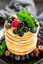 Pancakes with fresh berries. Pancakes with raspberry, blueberry, black currant and honey