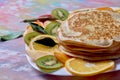 Pancakes with fruits on a bright background
