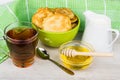 Pancakes in green bowl, jug milk, honey, teaspoon and tea Royalty Free Stock Photo