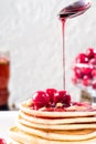 Pancakes homemade cake in stack decorated with berries frozen cherry Sprinkling with cherry syrup