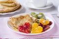 Pancakes with honey and heart shaped oranges and kiwi Royalty Free Stock Photo