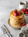 Pancakes with honey, strawberries, knife and fork and text space. Homemade breakfast concept