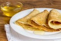 Pancakes with honey syrup on a white plate. traditional crepe or pancake