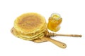 Pancakes on a kitchen table on a white background with a jar of honey. Kitchen concept