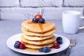 Pancakes with maple syrup, blueberries, cherries and a mini apple. Royalty Free Stock Photo