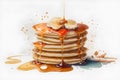 Pancakes with maple syrup and caramel on a white background. Royalty Free Stock Photo