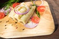 Pancakes with meat are laid out on a wooden board.