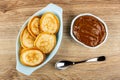 Pancakes in oval plate, sweet boiled condensed milk in bowl, spoon on table. Top view Royalty Free Stock Photo