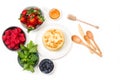 Pancakes on a plate and berries in bowls on a white background