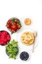 Pancakes on a plate and berries in bowls on a white background Royalty Free Stock Photo