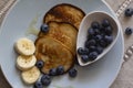 The pancakes on the plate are decorated with bananas, honey and blueberries, food and drink concept Royalty Free Stock Photo