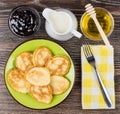 Pancakes in plate, fork on napkin, milk, honey and jam