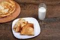 Pancakes in a plate and a glass of milk are on a dark table. Royalty Free Stock Photo