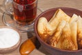 Pancakes on a plate with sour cream on an oak table