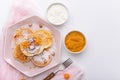 Pancakes with raspberries and physalis, powdered sugar and maple syrup in pink plate with sour cream and mango jam on white Royalty Free Stock Photo