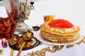 Pancakes with red caviar on the background of samovar and wooden dishes in Khokhloma style