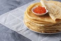 Pancakes with red caviar on grey background, with copy space for text