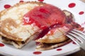 Pancakes with red currant jam in white plate in red peas