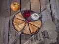 Pancakes rolled by a triangle on a large gray plate, a number of small ice-cream bowls with sour cream and canned Royalty Free Stock Photo