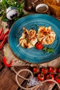 Pancakes with salmon, cream cheese and herbs. Bags tied with dill on a blue plate, next to the products for cooking