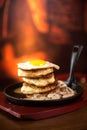 Pancakes with sausage and scrambled eggs in a frying pan