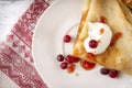 Pancakes with sour cream, berries, cranberries and jam on a plate, tea, jam on a towel with a red pattern on a white background, Royalty Free Stock Photo