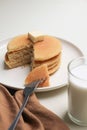 Pancakes stack topping butter and a glass of milk