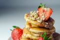 Pancakes stacked with bananas, strawberries and nuts, topped with chocolate and strawberry sauce Royalty Free Stock Photo